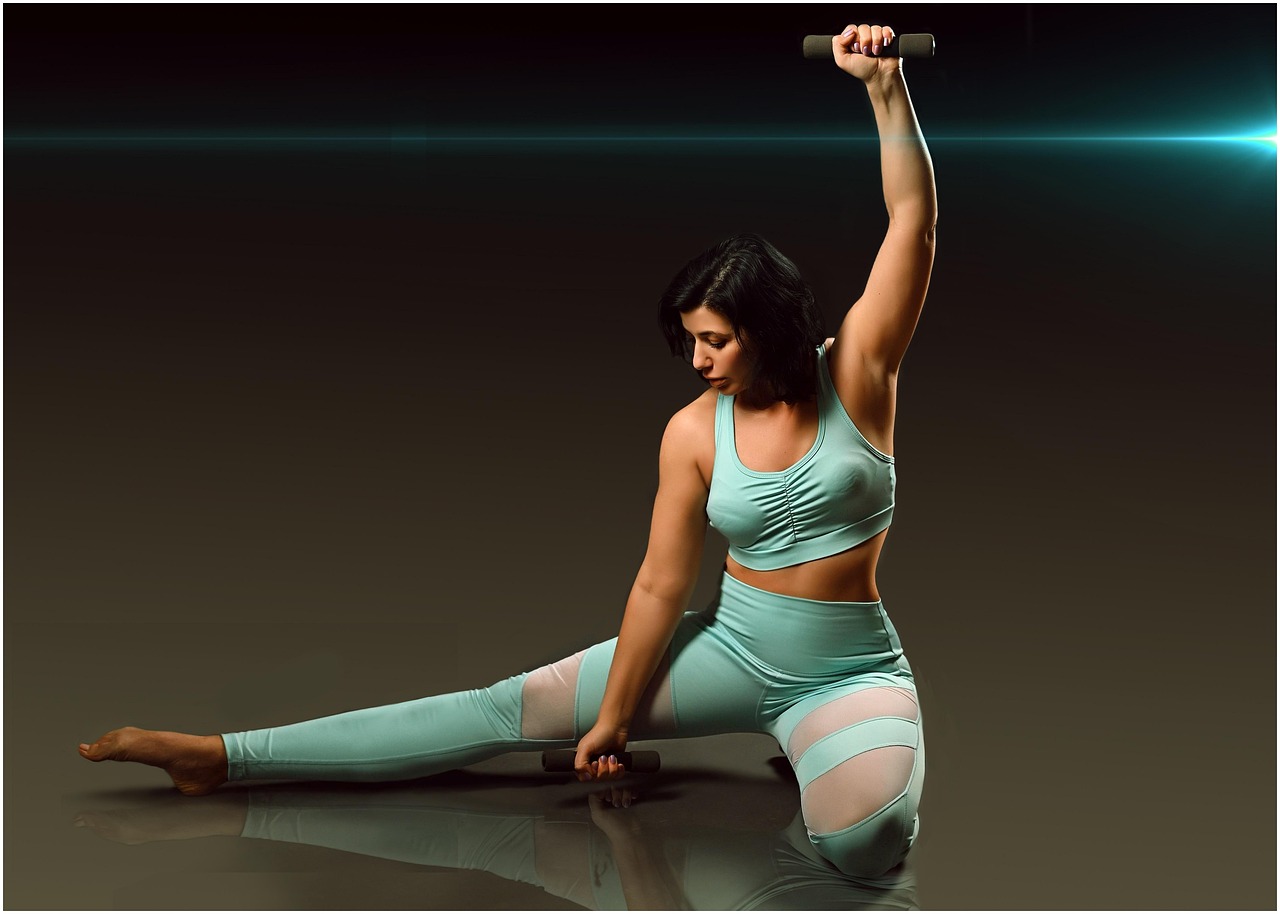 A young woman in a yoga pose. She is wearing a light blue sports bra and leggings, and her hair is styled in a sleek bob. The...