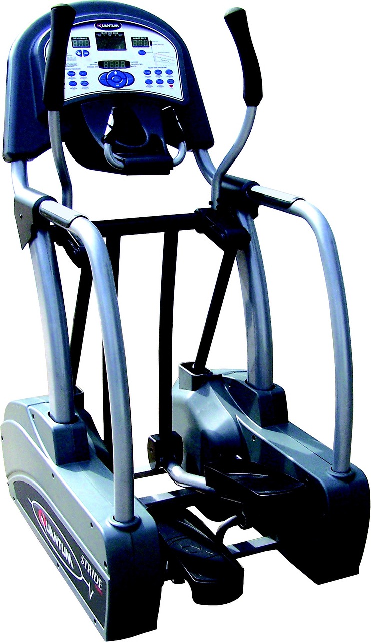 A close-up of a stationary exercise machine. The machine is grey and black in color and has a digital display on the front pa...