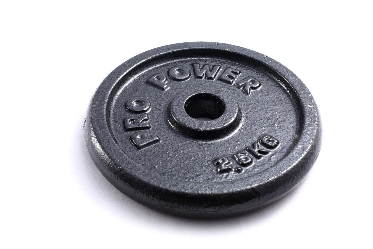 A close-up of a black rubber weight plate with the words "PRO POWER" and "25kg" embossed on it. The plate appears to be made ...
