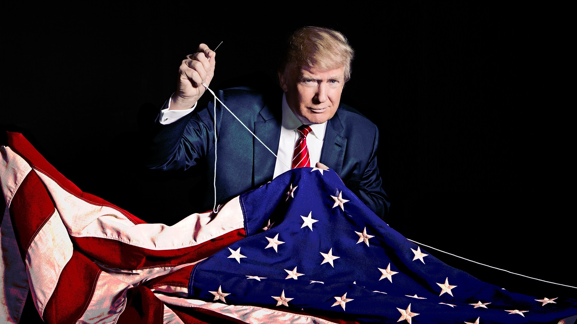 A man in a suit and tie holding an American flag. The man is Donald Trump, the former president of the United States. He is s...