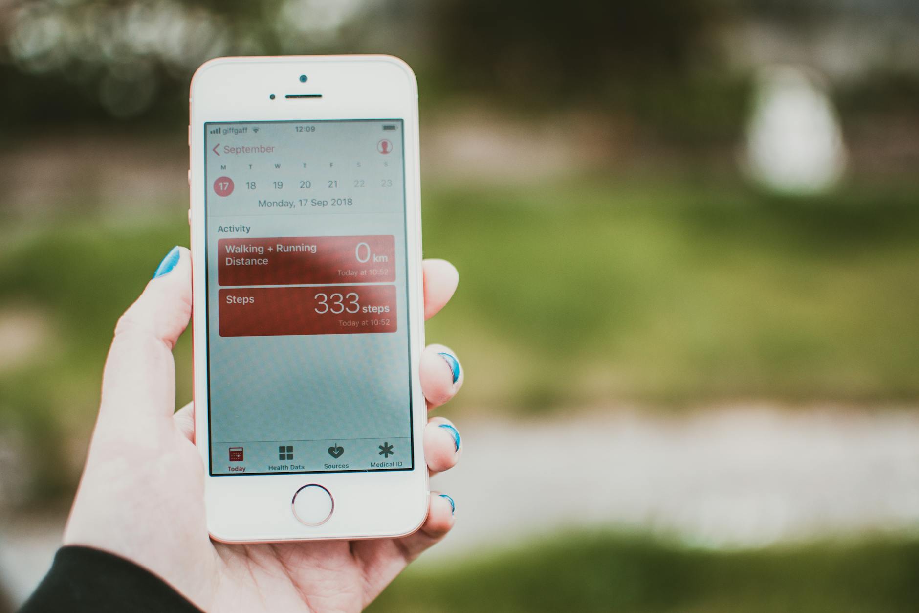 A person's hand holding an iPhone with a fitness tracker app open on the screen. The app appears to be a workout tracker app,...